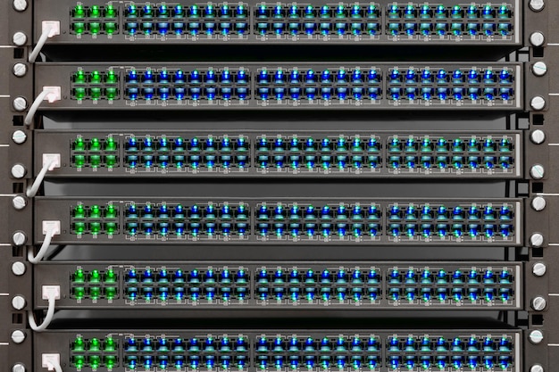 ISPのネットワークルーター多くのワイヤーは、強力なインターネットサーバーのネットワークインターフェイスに接続します。サーバールームのデータセンターにあるコンピューター機器を備えたラック