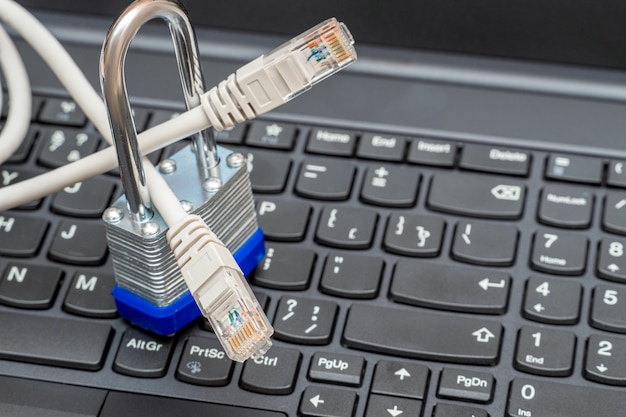 Photo network wires blocked with a metal lock on the keyboard