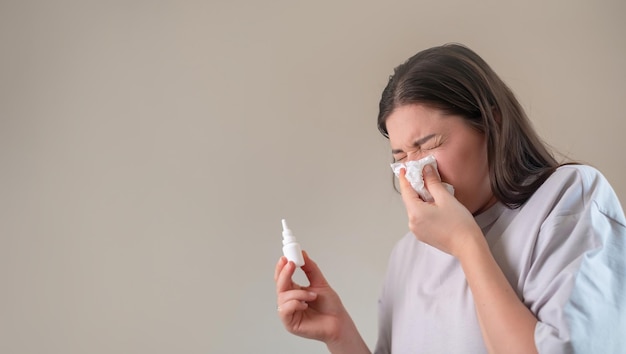 Neushygiëne met spray meisje maakt de neusgaten schoon door in een zakdoek te blazen