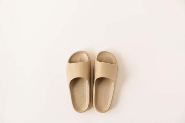 Neutrale beige kleur zomer slippers geïsoleerd op een witte achtergrond Plat lag bovenaanzicht minimalistische mode concept