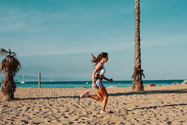 あきらめないで！屋外で運動しながらジョギングスポーツ服の美しい若い女性の全長