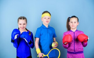 Never stop workout of small girls boxer and boy in sportswear happy children in boxing gloves with tennis racket and ball fitness energy health punching knockout team sport success