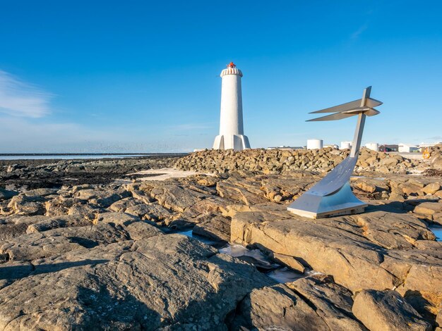 The new active akranes lighthouse tower at end peninsula in city under blue sky iceland