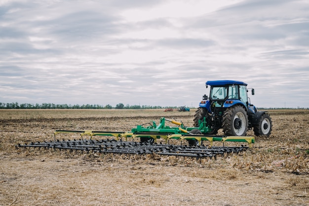 New agricultural machinery, tractors in motion at demonstration field site at agro exhibition