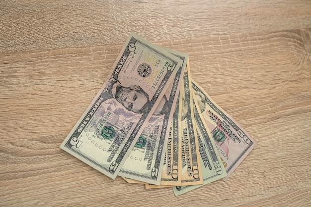 New banknotes of dollars with car keys laid out on a new wooden table. Business concept