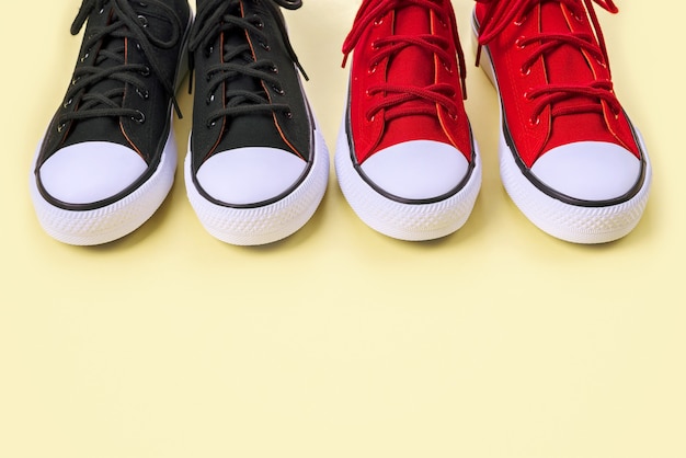 Nuove sneakers nere e rosse su giallo con spazio di copia.