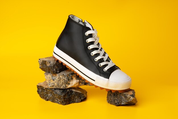 New black and white canvas sneakers on yellow background