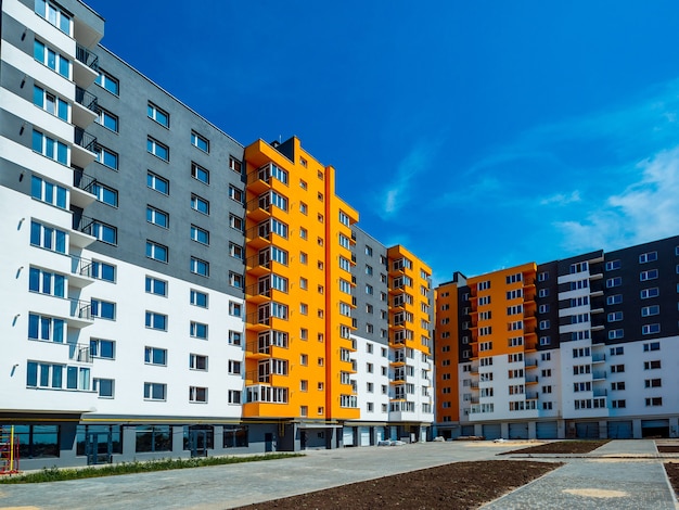 New block of modern apartments with balconies and blue sky in the background