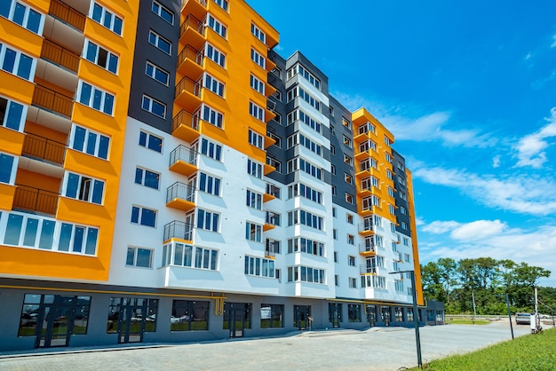 Фото Новый блок современных квартир с балконами и голубым небом на заднем плане