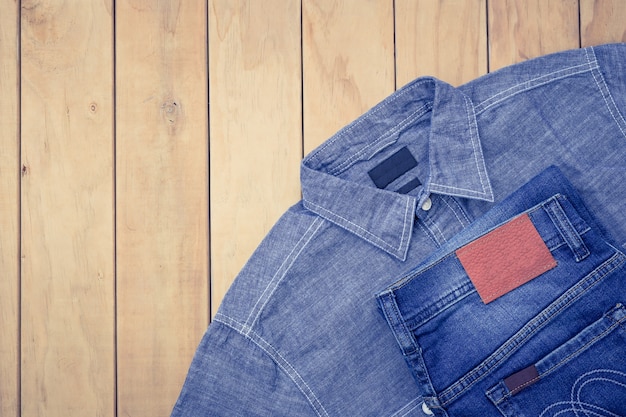 New blue jeans on wooden background top view