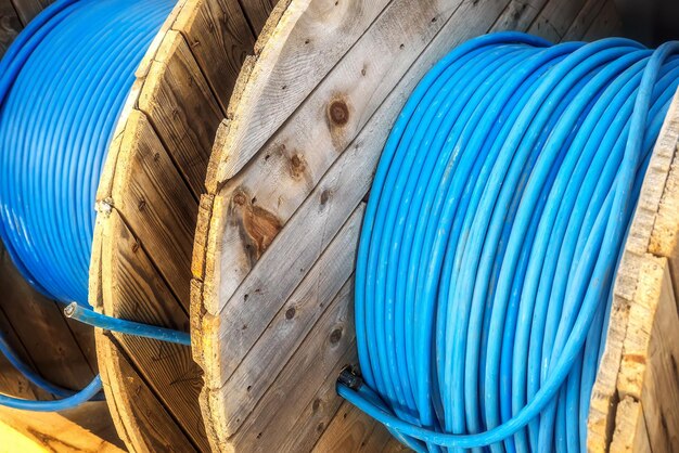 New blue power cable is wound on wooden coil background cable for laying underground