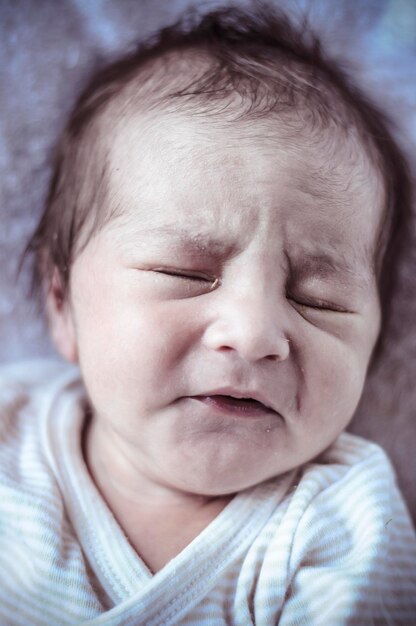 new born baby curled up sleeping on a blanket, multiple expressions