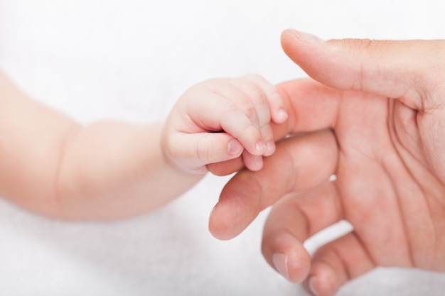 Новорожденный ребенок рука держит руку куман