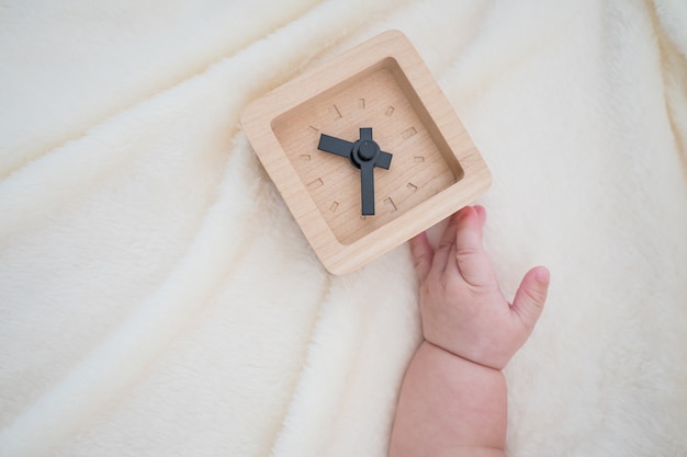 new born baby and wooden clock