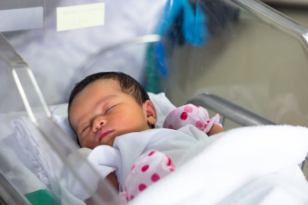 new born infant asleep in the blanket in delivery room