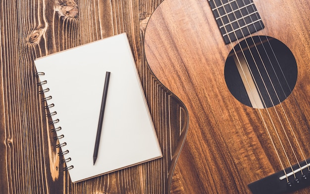 New brown guitar on wooden board 