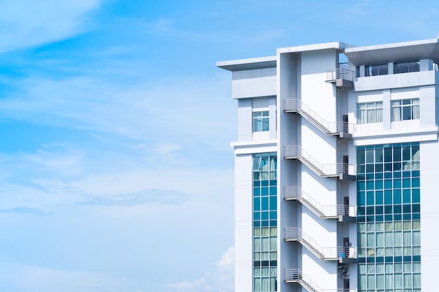 New building architecture with fire escape stairs on blue sky backgroundLow angle architectural exterior view of modern