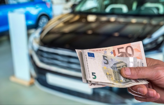 New car. buy or rent. hand holding euro banknotes. finance