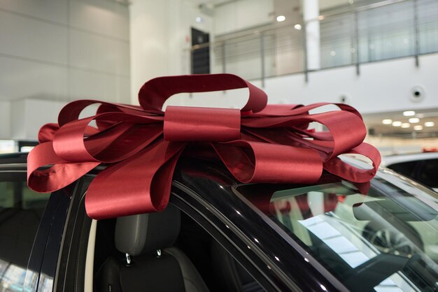 The new car is wrapped in a red bow Beautiful gift concept