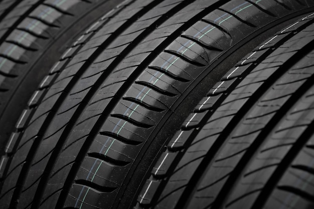 New car tires Group of road wheels on dark background Summer Tires with asymmetric tread design Driving car concept Closeup