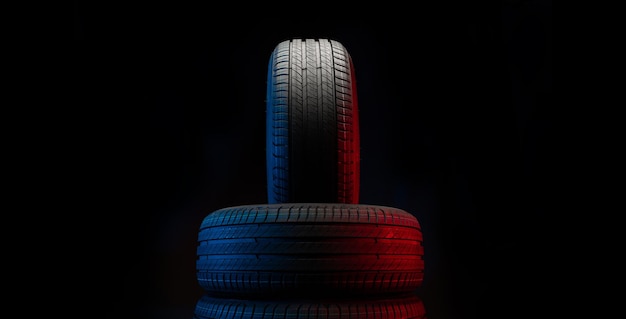 새 자동차 타이어 어두운 배경의 도로 바퀴 그룹 비대칭 트레드 디자인이 있는 여름 타이어 운전 자동차 개념