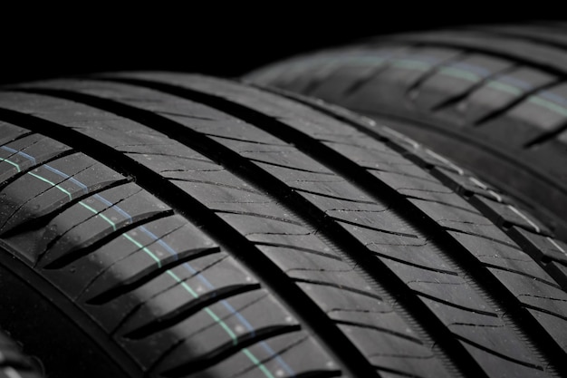 New car tires Group of road wheels on dark background Summer Tires with asymmetric tread design Driving car concept