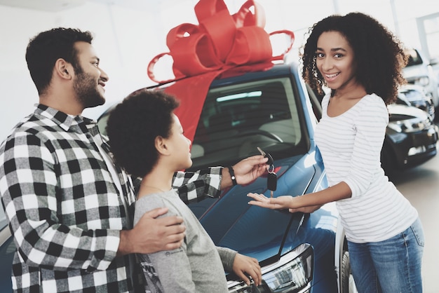 Photo new car with red bow man gives keys to woman