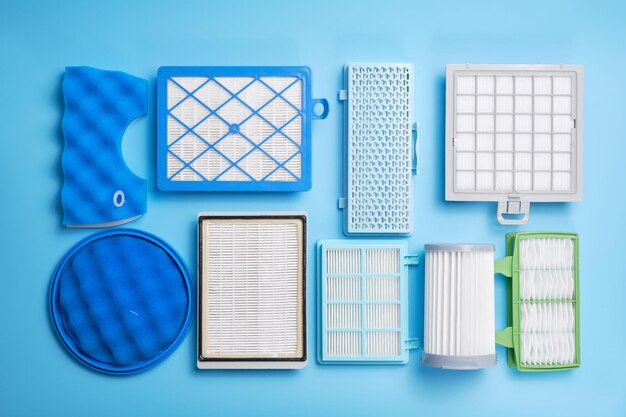 New clean dust air filters for vacuum cleaner isolated on blue background