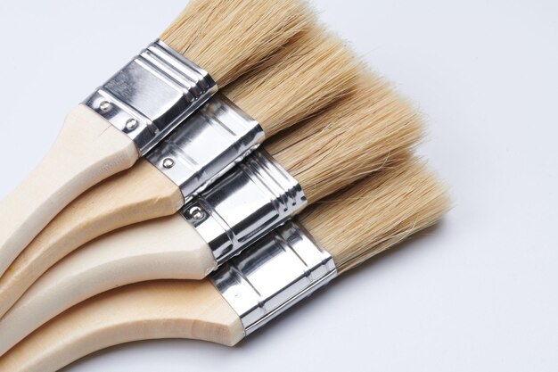 New clean wooden paint brushes isolated on white background closeup