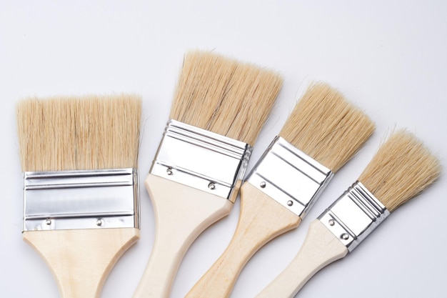 New clean wooden paint brushes isolated on white background closeup