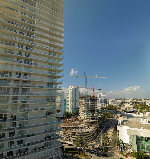 Photo new construction site of developing residense in american urban area industrial tower lifting cranes in miami florida concept of housing growth in the usa