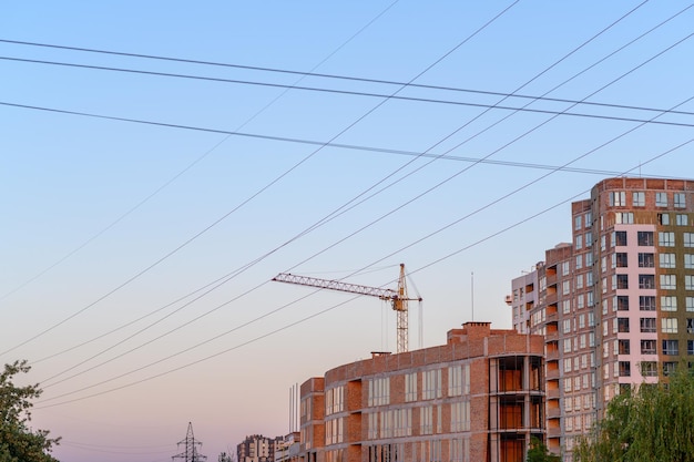 New construction site with cranes on sunset background