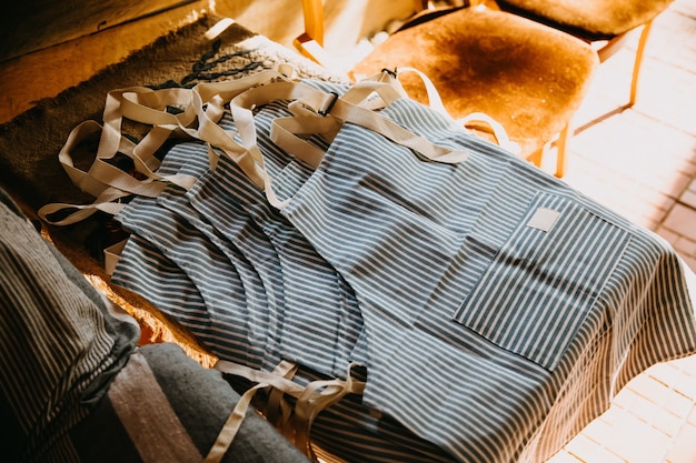 New cotton striped aprons lying on a table