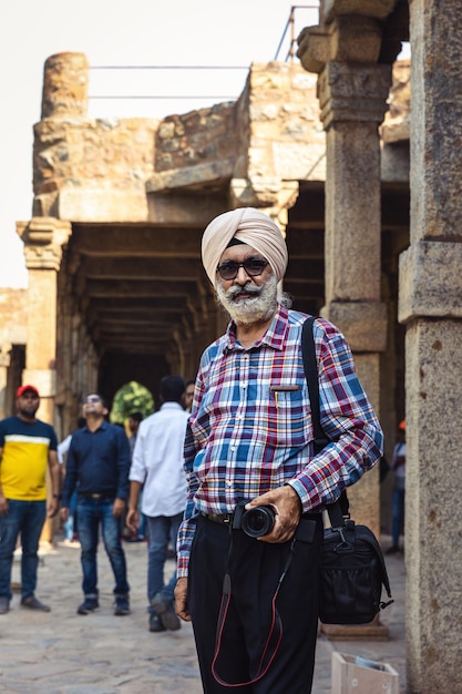 Photo new delhi india 02272023 indian man in a turban with a camera in the temple complex of qutub mi