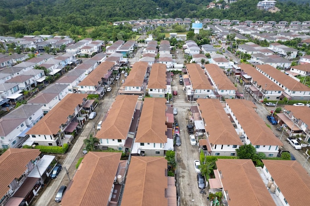 New development real estate aerial view of residential houses\
and driveways neighborhood during a fall sunset or sunrise\
timetightly packed homestop down view over private houses in phuket\
thailand