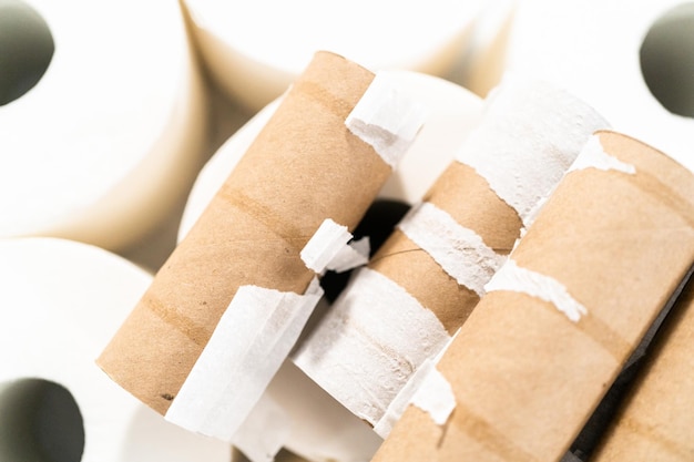 New and empty white toilet paper rolls on a gray background.