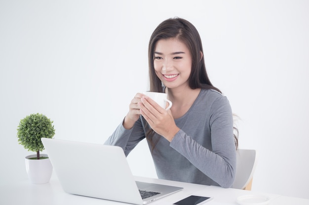 New generation asians business woman sitting and drinking coffee using laptop