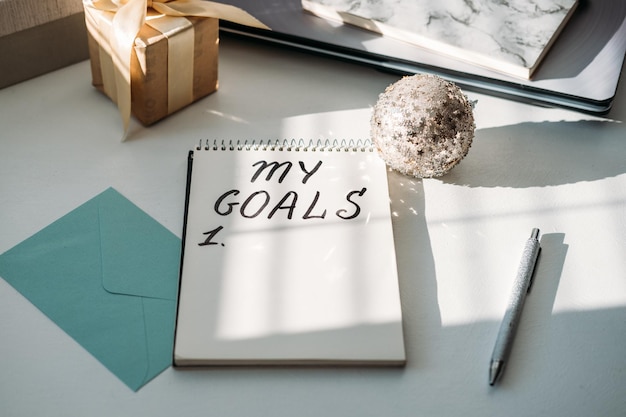 New goals new year resolution handwritten text my goals in open notepad on the table start new year