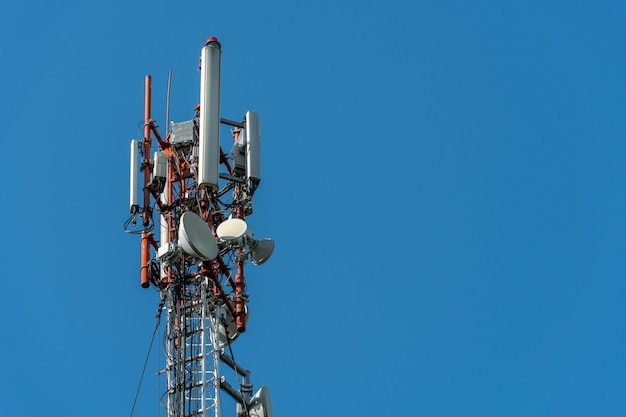 New GSM antennas on a high tower against a blue sky for transmitting a 5g signal are dangerous to health Radiation pollution of the environment through cell towers The threat of extinction