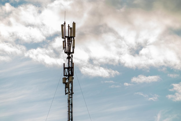 5g 신호를 전송하기 위해 푸른 하늘을 배경으로 높은 타워에 새로운 GSM 안테나는 건강에 위험합니다. 기지국을 통한 환경의 방사선 오염 멸종의 위협