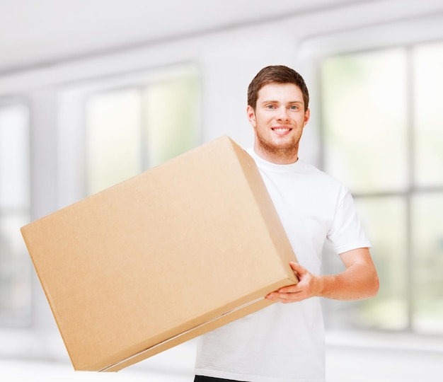 new home and post delivery concept - smiling man carrying carton box