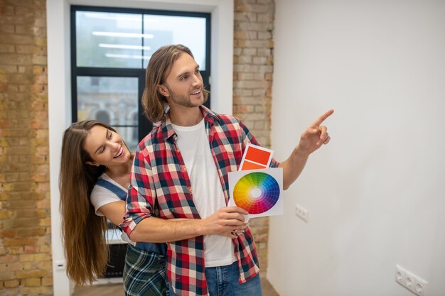 Nuova casa. coppia giovane discussng il colore della parete in una nuova casa e sorridente