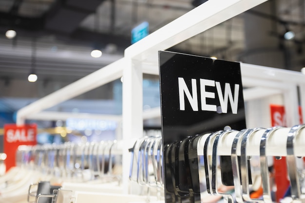 NEW label on clothes rack in the woman clothing shop.