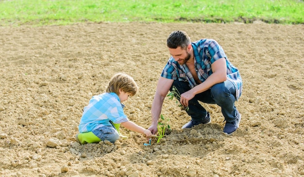 New life soils fertilizers rich natural soil Eco farm father and son planting flowers in ground earth day small boy child help father in farming happy earth day Family tree Water on leaves