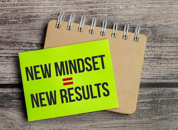 Photo new mindset new results on green sticker and notebook