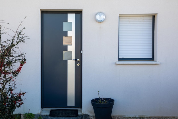 Photo new modern gray door with aluminum entrance to the house facade