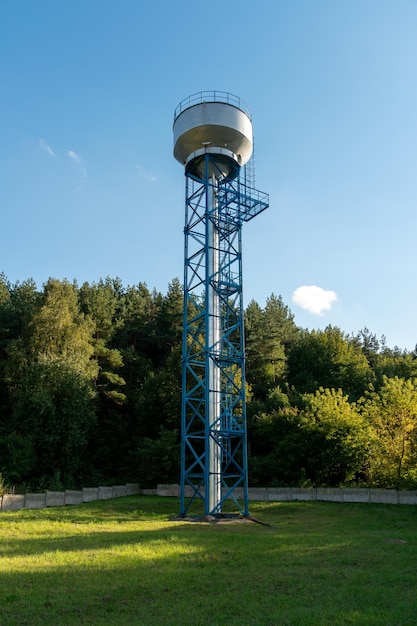 Foto nuova moderna torre dell'acqua sullo sfondo del cielo blu e della foresta metodi di stoccaggio dell'acqua per l'irrigazione delle colture agricole in condizioni climatiche e meteorologiche difficili un barile con acqua