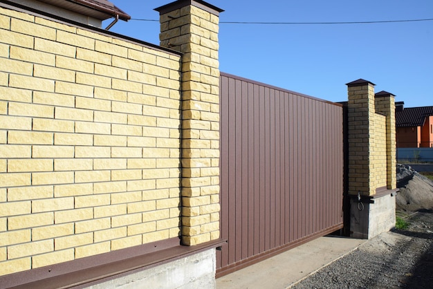 New modern yellow high metal fence in early spring