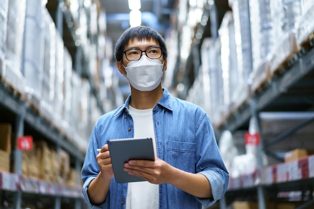 New Normal Asian men, staff, product wearing face mask. counting Warehouse Control Manager Standing, counting and inspecting products in the warehouse