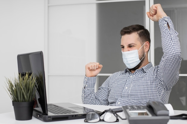 Nuovo normale in ufficio con maschera facciale